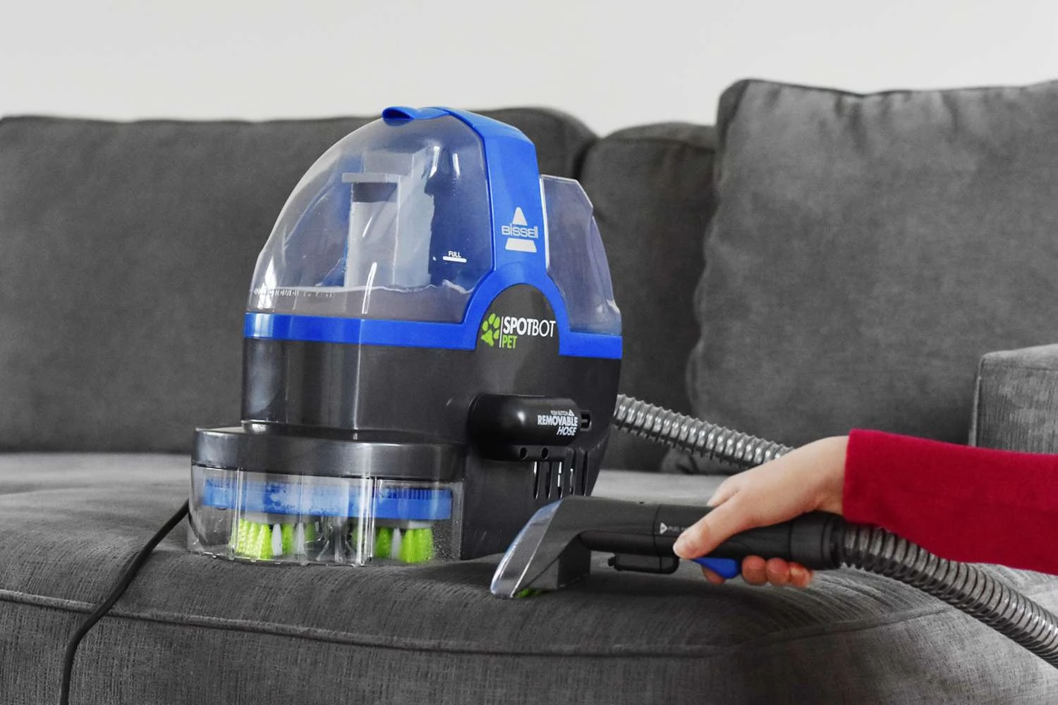 Upholstery cleaning equipment on a gray sofa